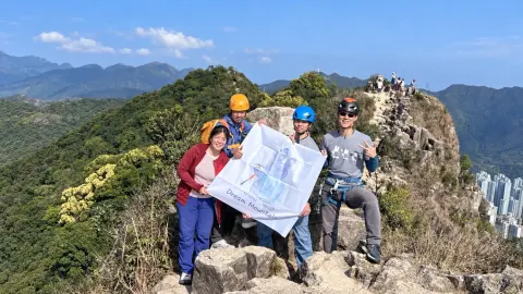 攀登者在香港天然岩壁上練習，遠處可見城市與山林